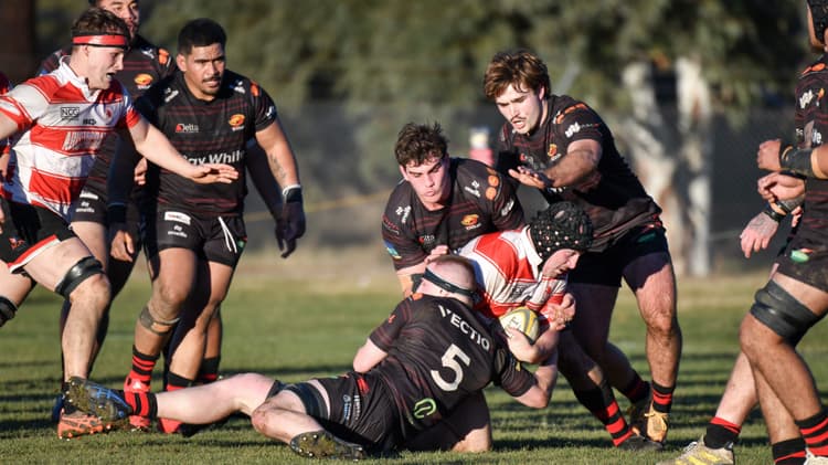 Lachlan Lonergan tackled by Gungahlin Eagles defenders. Image Supplied by Jayzie Photography.