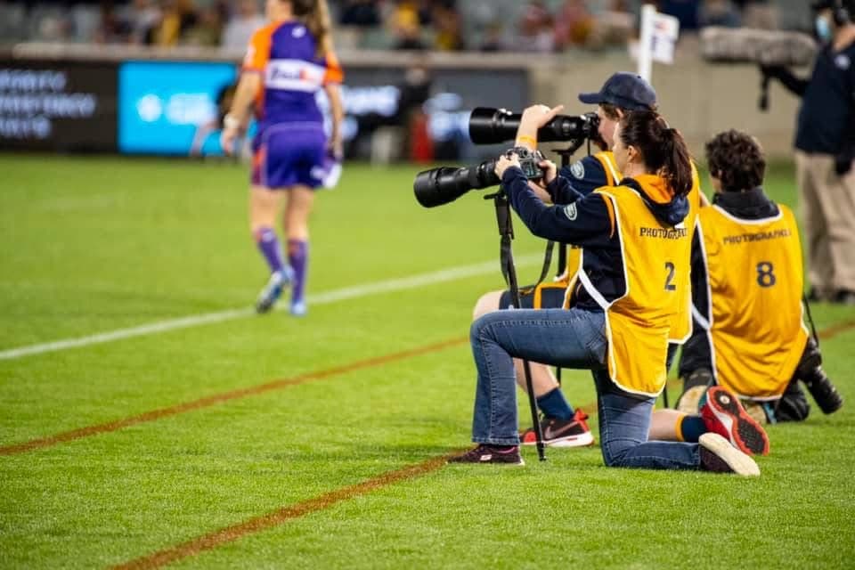 Jaye Grieshaber shooting on the sidelines of GIO Stadium during an ACT Brumbies match.
